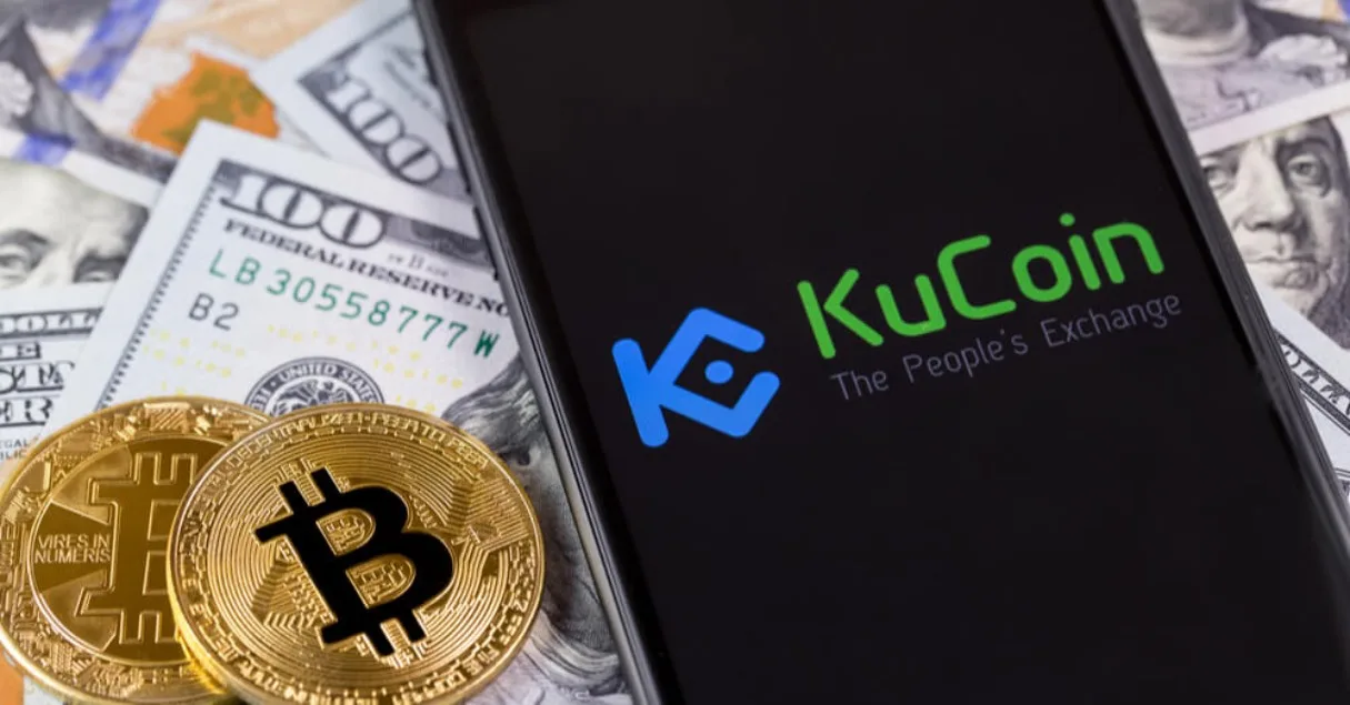 لوگوی کوکوین (KuCoin) روی موبایل کنار بیت کوین