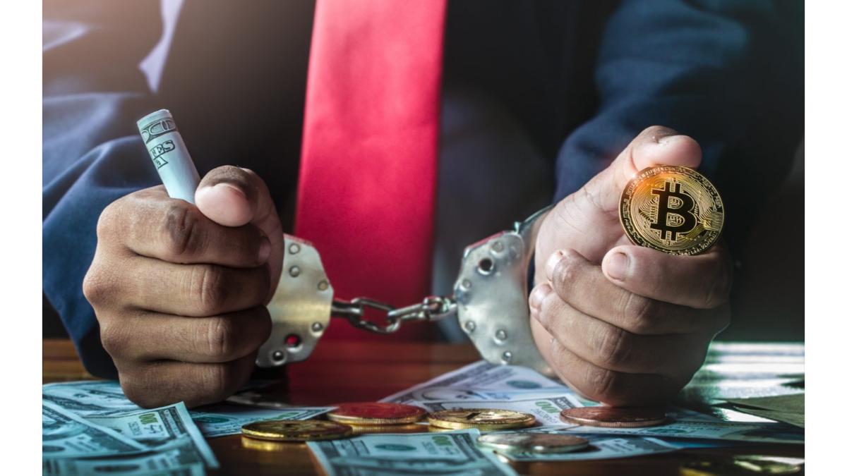 مردی که دستبند بر دستش است. در یک دست سکه بیت‌کوین دارد و در دست دیگر پول نقد.