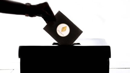 روی یک برگه‌ی رای که در حال انداخته شدن به صندوق است علامت سکه‌ی اتریوم قرار دارد.