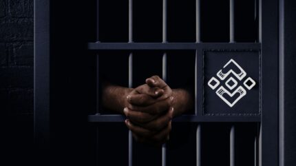دو دست روی میله‌های سلول زندان و لوگوی صرافی بایننس روی در سلول.