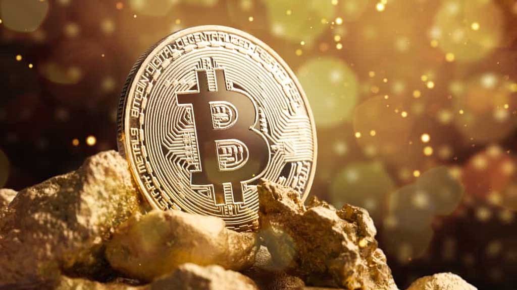 یک سکه بیت کوین در کنار سنگ‌های طلا