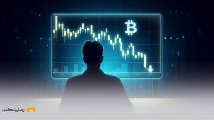 فردی که با نگرانی به نمودار سقوط بیت‌کوین روی صفحه نمایش نگاه می‌کند